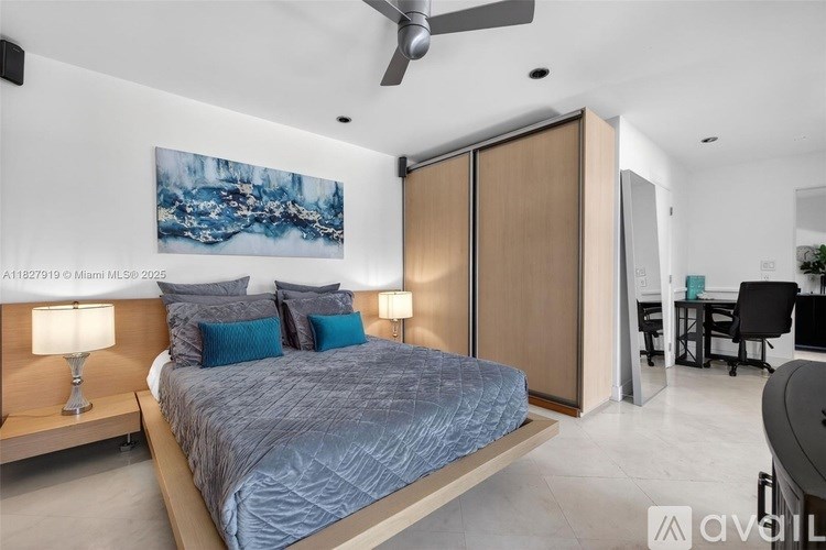 A bedroom with a bed, two lamps, and a painting on the wall.