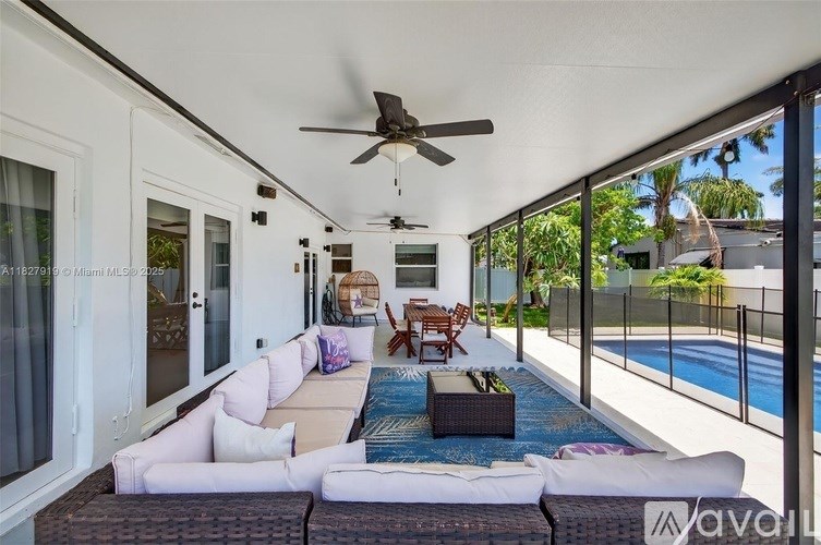 A modern outdoor living space with a pool and patio furniture.