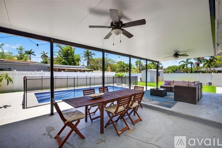 A patio with a table and chairs overlooking a pool.