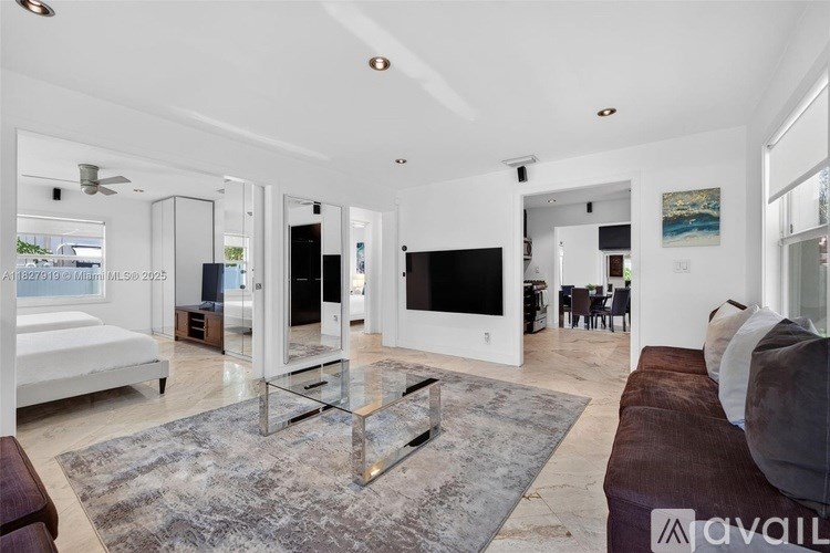 A modern living room with a glass coffee table and a large flat screen TV.