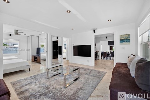 A modern living room with a glass coffee table and a large flat screen TV.