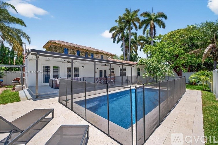 A house with a pool surrounded by a fence.