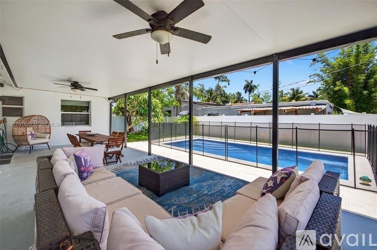 A modern outdoor living space with a pool and a ceiling fan.