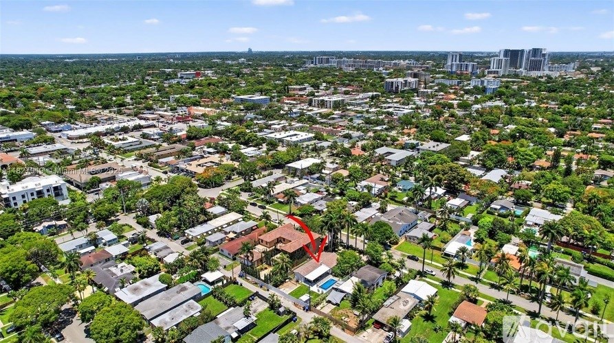 A red arrow points to a house in a residential area.