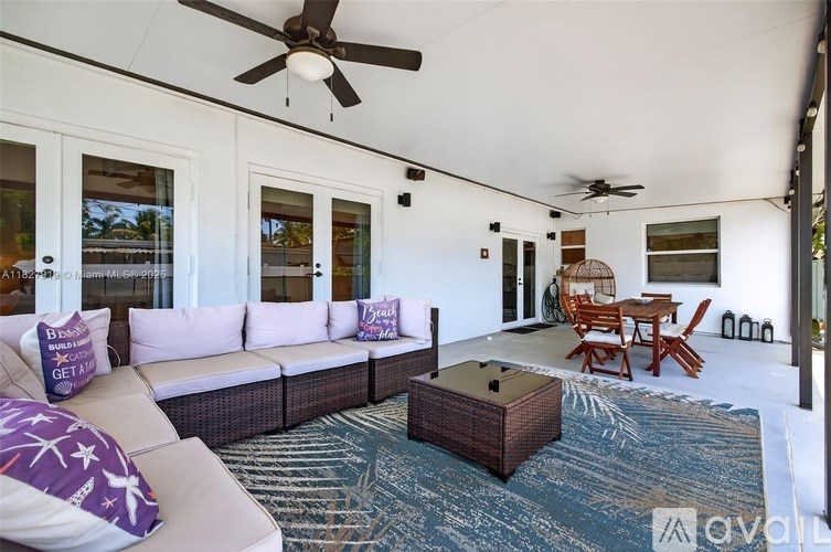 A living room with a white couch and a ceiling fan.