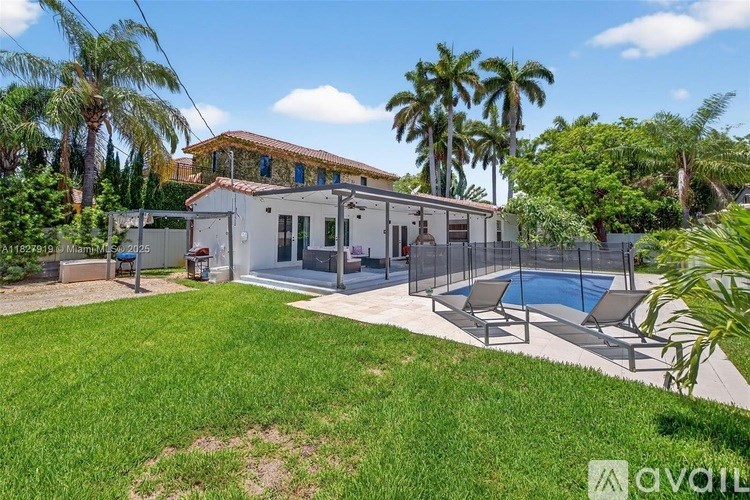 A house with a pool and a fence in front of it.