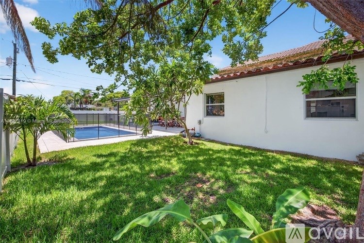 A backyard with a pool and a house.