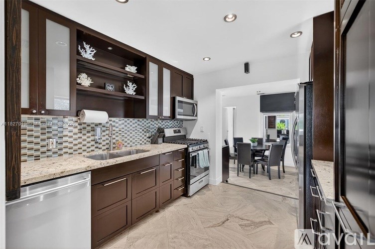 A kitchen with brown cabinets and a white dishwasher.