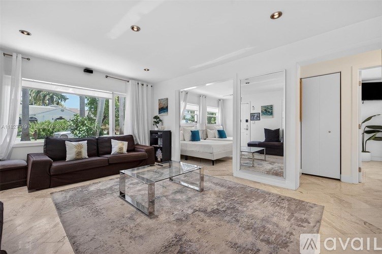 A modern living room with a brown leather couch and a glass coffee table.
