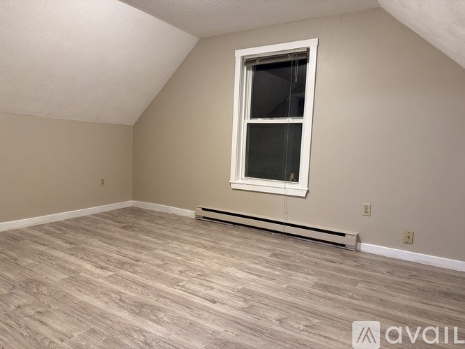 A room with a window and a radiator on the floor.