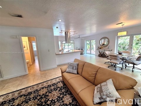 A living room with a tan couch and a rug.
