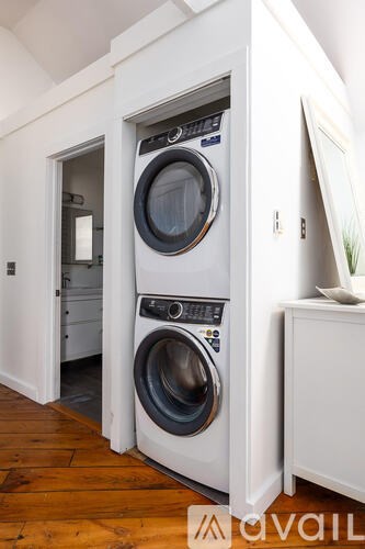 A white washing machine is in a cabinet.