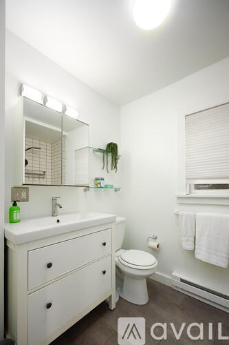 A bathroom with a white sink and toilet.