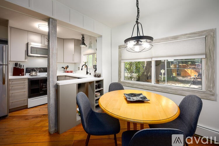 A kitchen with a table and chairs in front of a window.
