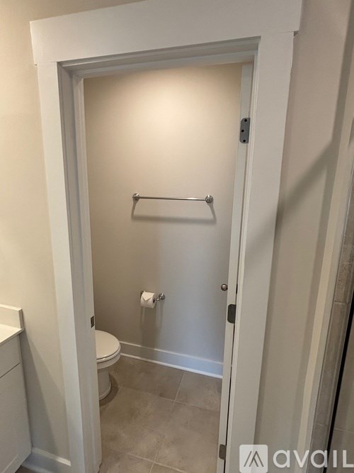 A white door with a towel bar and toilet paper holder.