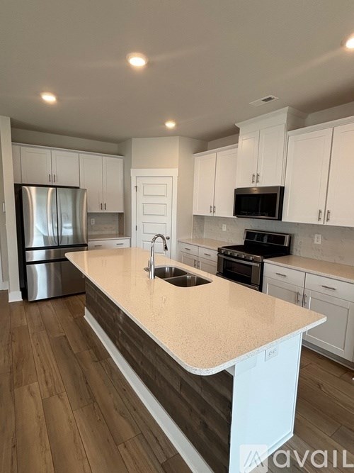 A kitchen with a sink and a refrigerator.