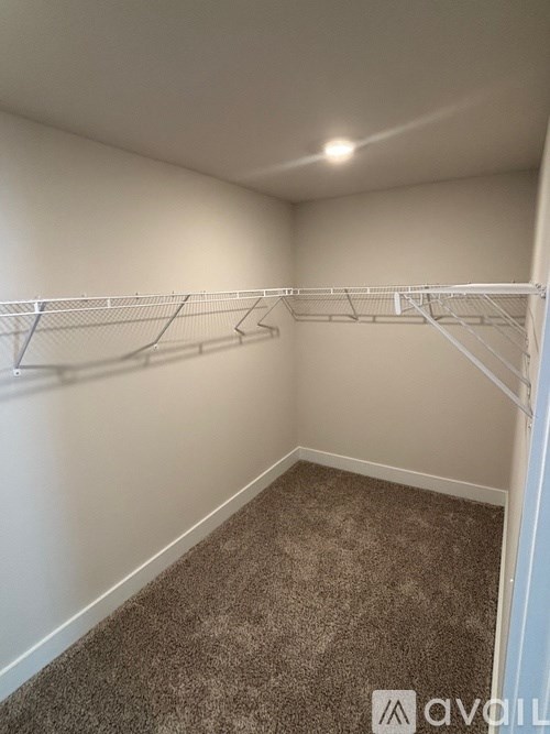 Empty room with a carpeted floor and a metal rack on the wall.