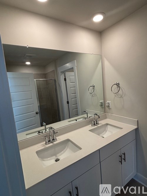 A bathroom with two sinks and a large mirror.