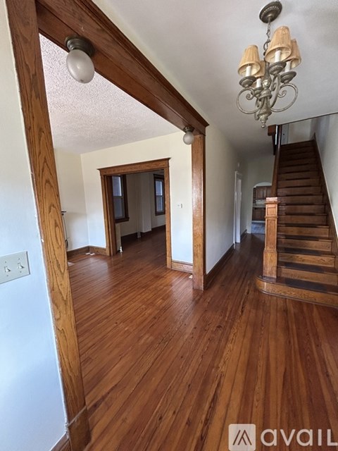 A room with wooden floors and a staircase.