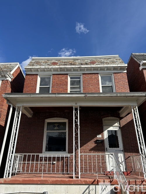 A red brick house with a white door and windows.
