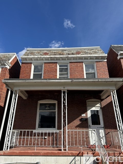 A red brick house with a white door and windows.