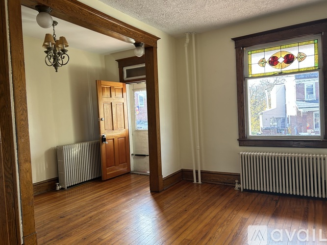 A room with wooden floors and a stained glass window.
