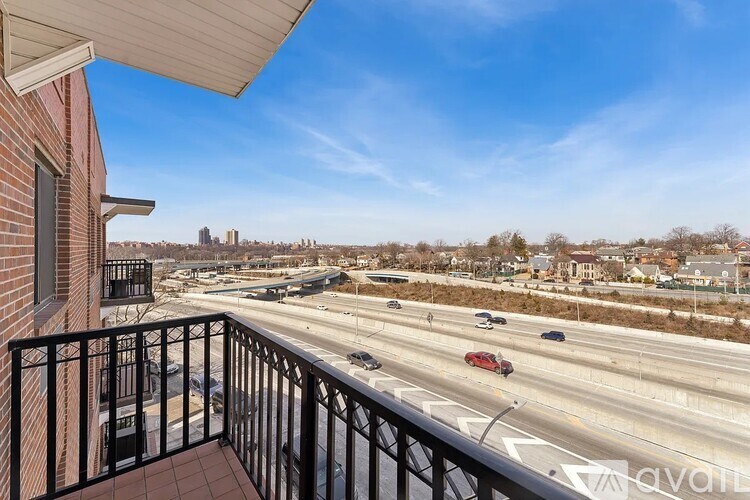 A balcony overlooks a busy highway with cars and buildings in the distance.