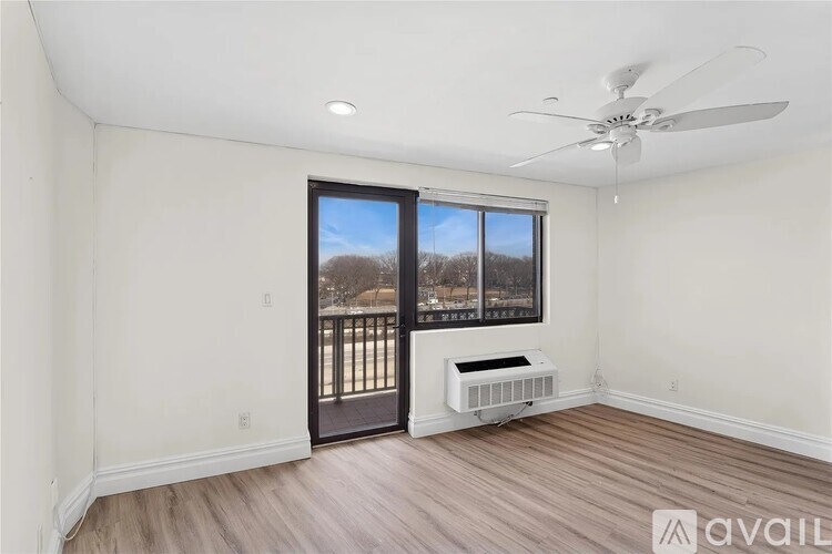 A room with a fan, window and a heater.