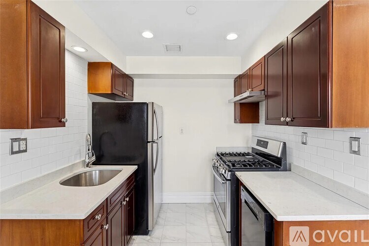 A kitchen with a black refrigerator, stove, and sink.