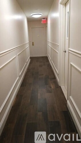 A hallway with wood floors and white walls.