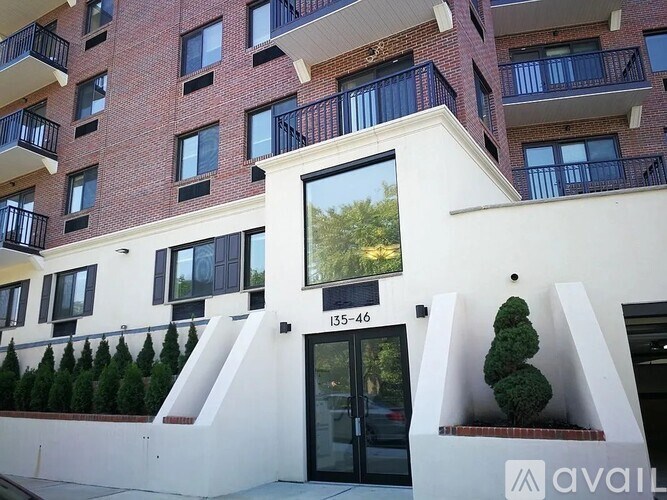 A building with a white facade and a balcony with black railings.
