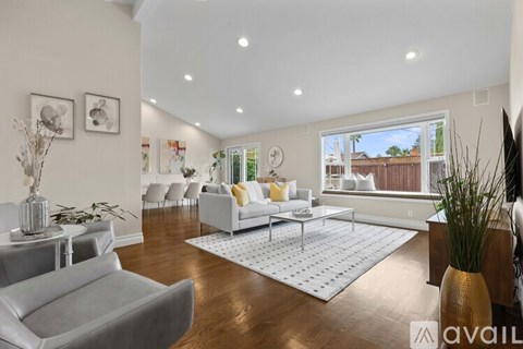 A living room with a grey sofa and a white rug.