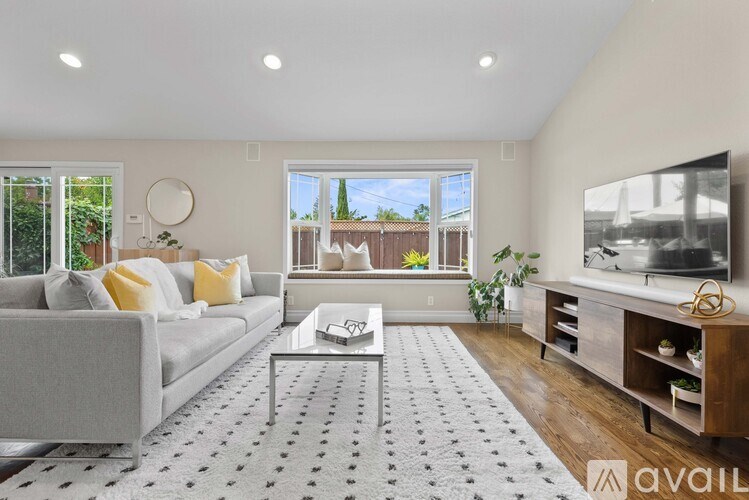 A living room with a grey sofa, a coffee table, and a television.