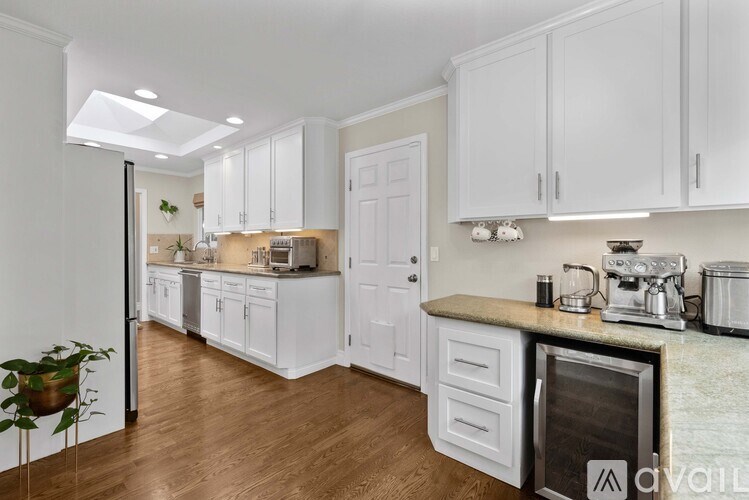 A kitchen with white cabinets and a marble countertop.