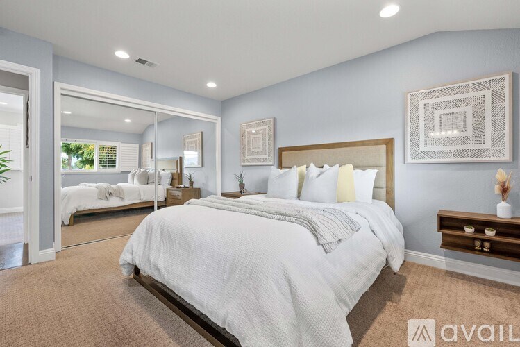 A bedroom with a large bed and a mirror on the wall.