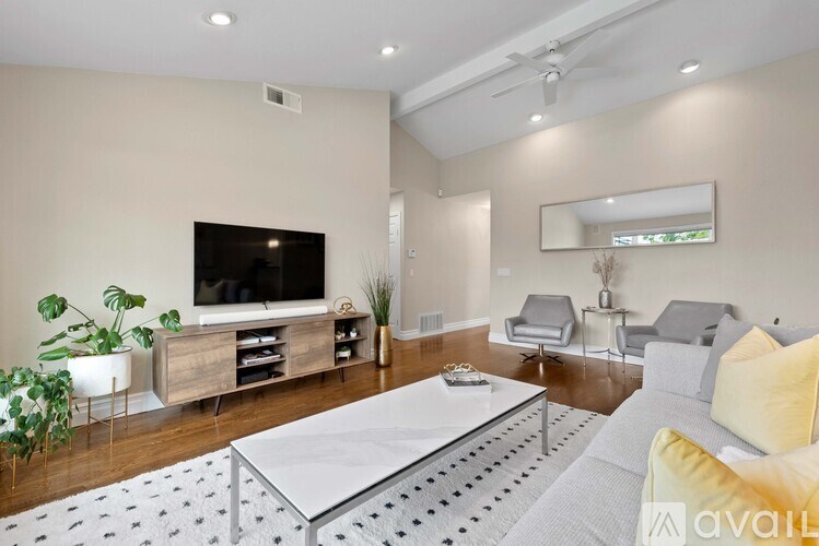 A modern living room with a white coffee table and grey sofa.