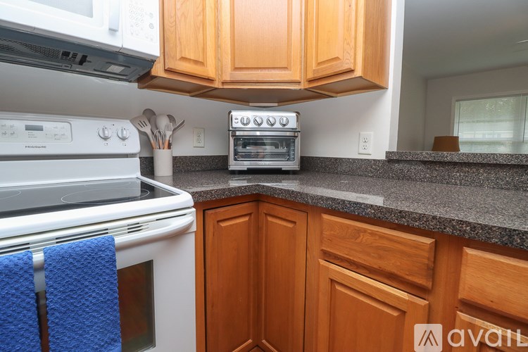 A kitchen with wooden cabinets and a granite countertop.