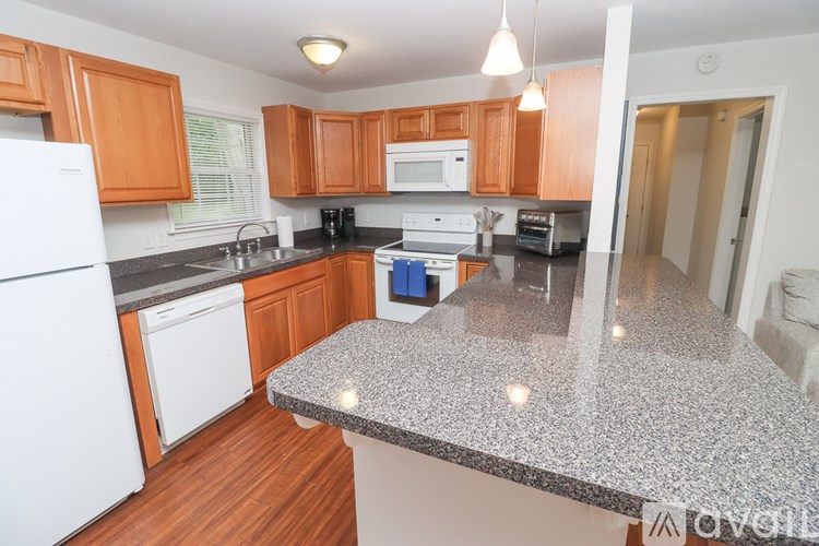 A kitchen with wooden cabinets and a granite countertop.