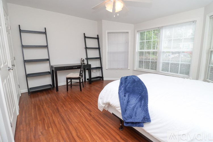 A bedroom with a bed, desk, and chair.