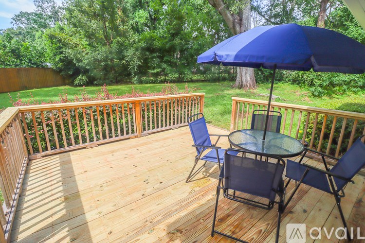 A wooden deck with a table and chairs and an umbrella.