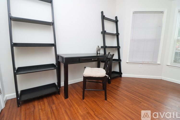 A black chair and desk with a chair in front of it.
