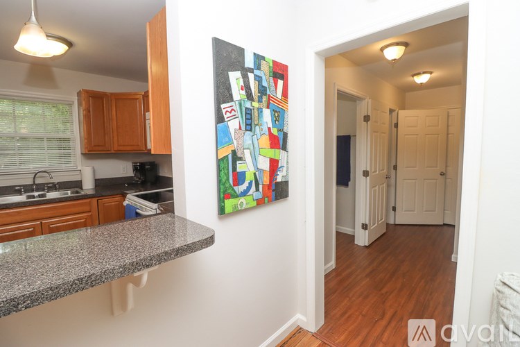 A kitchen with a painting on the wall.