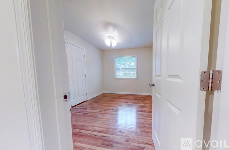A room with white walls and a wooden floor.