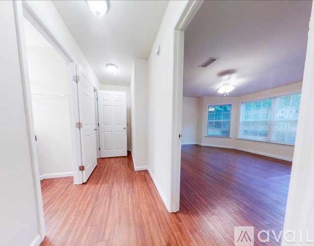 A hallway with wood floors and white walls.