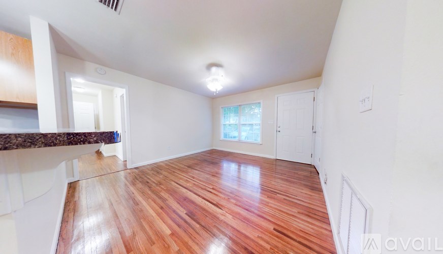 A room with wooden flooring and white walls is available for rent.