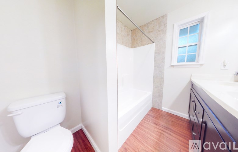 A white toilet in a small bathroom with a window.