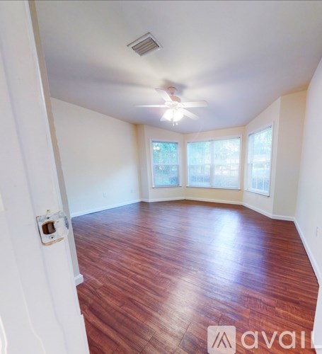 A room with wooden floors and a ceiling fan.