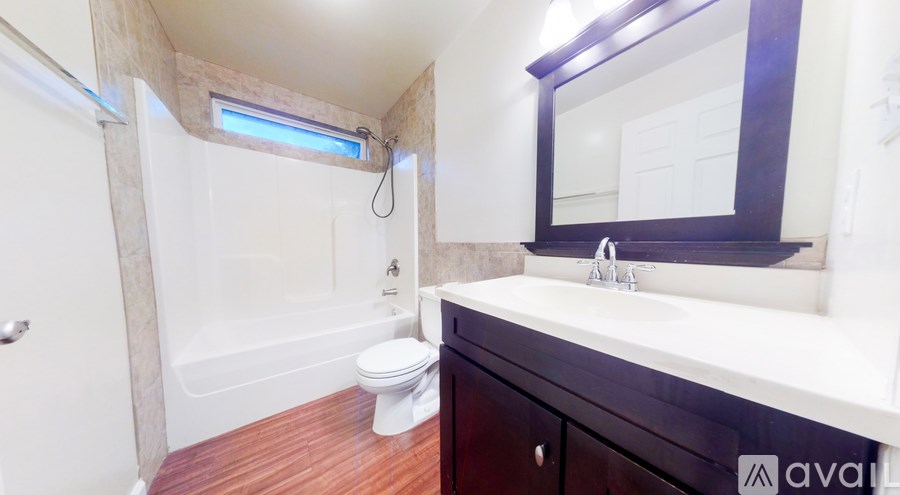 A bathroom with a toilet, sink, and mirror.