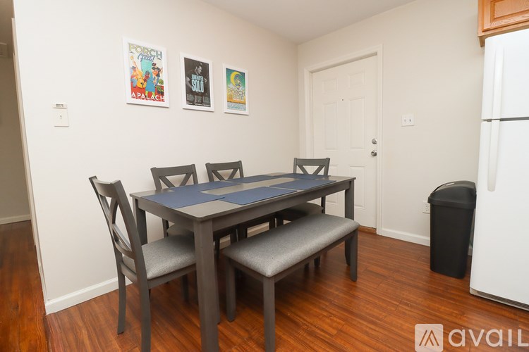 A dining table with four chairs and a bench is in a room.