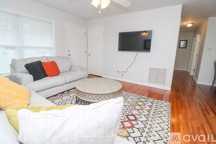 A living room with a grey couch and a white chair.